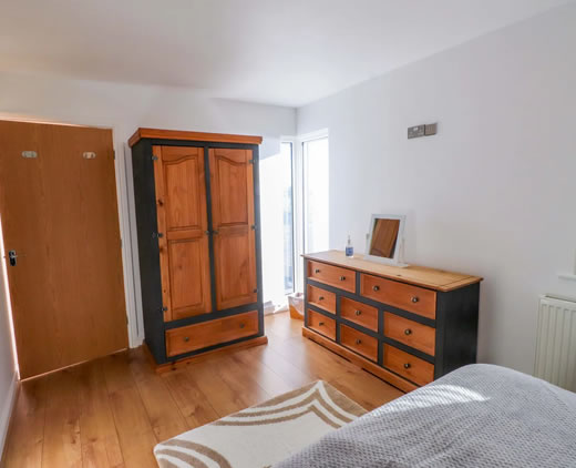 Bright modern bedroom with fresh linens at Sea Breeze Retreat Pwllheli